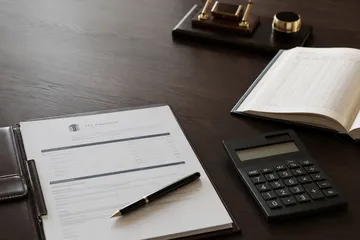 Fee proposal, calculator, and ledger arranged on a desk